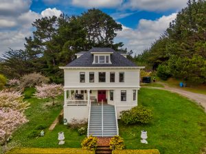 White home on hill with steps leading up to red door