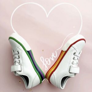 a pair of colorful shoes laying on paper with a heart drawn on it that says love